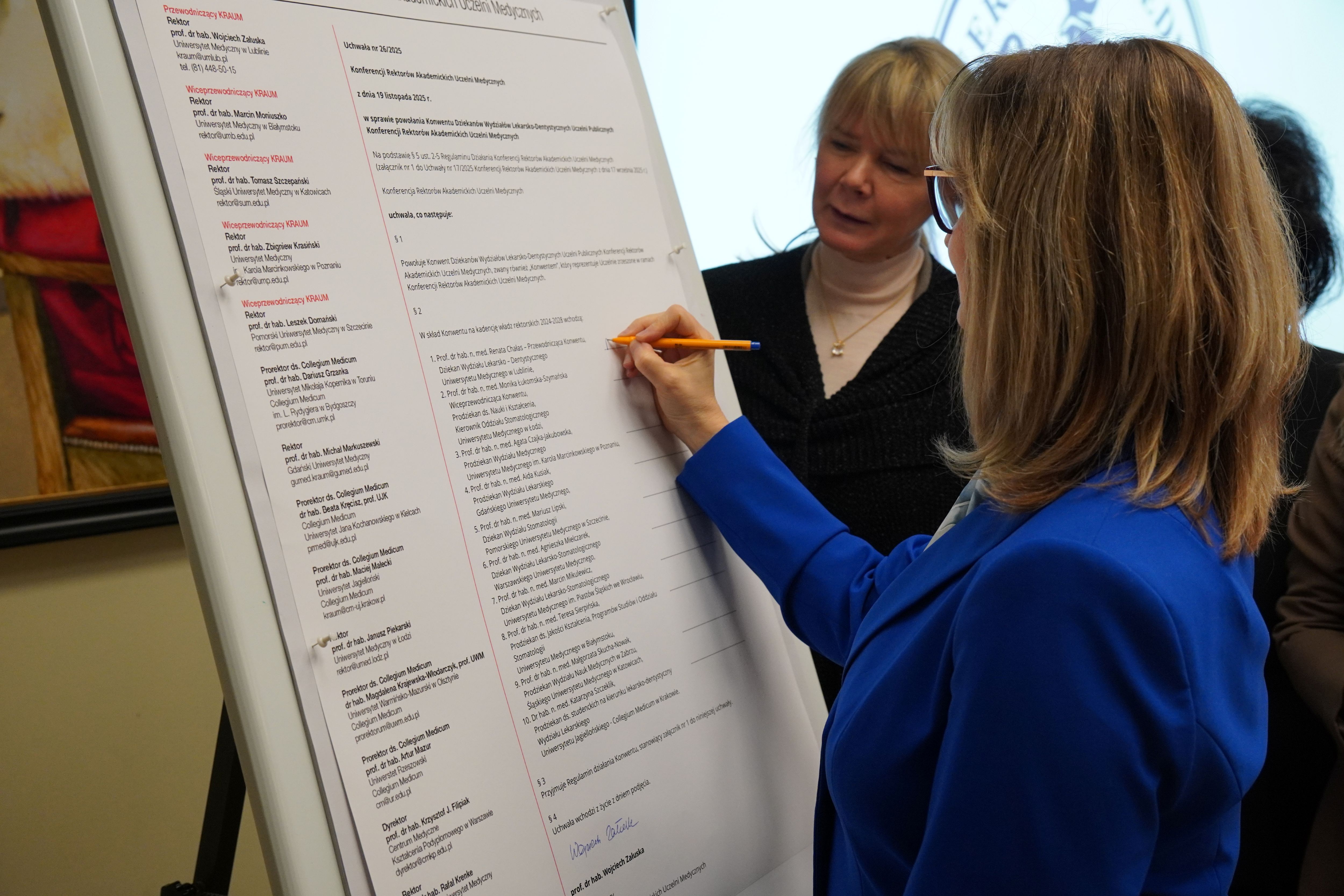 dziekan Chałs składa podpis na dokumencie