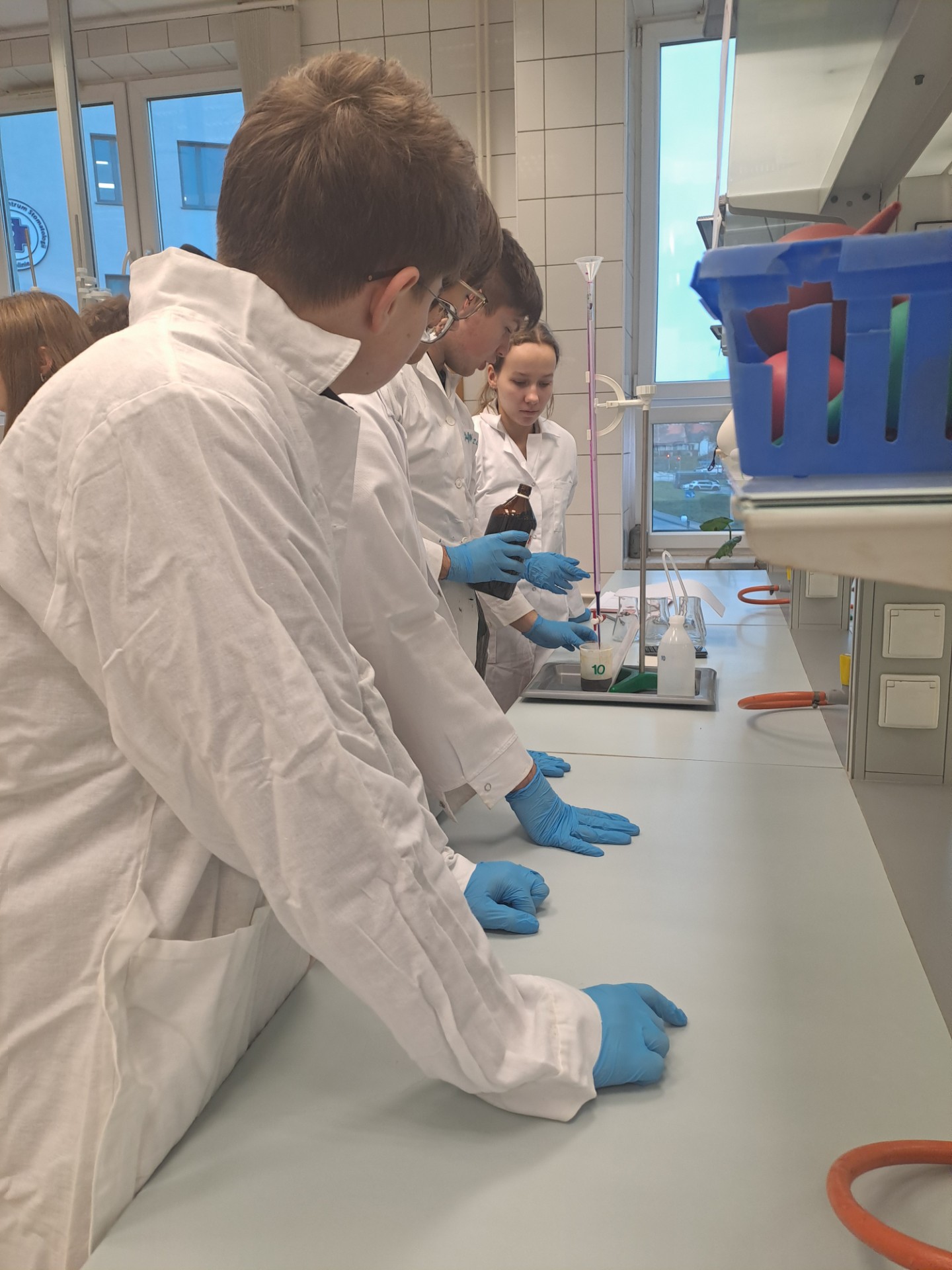 pracownia chemiczna i uczniowie w fartuchach