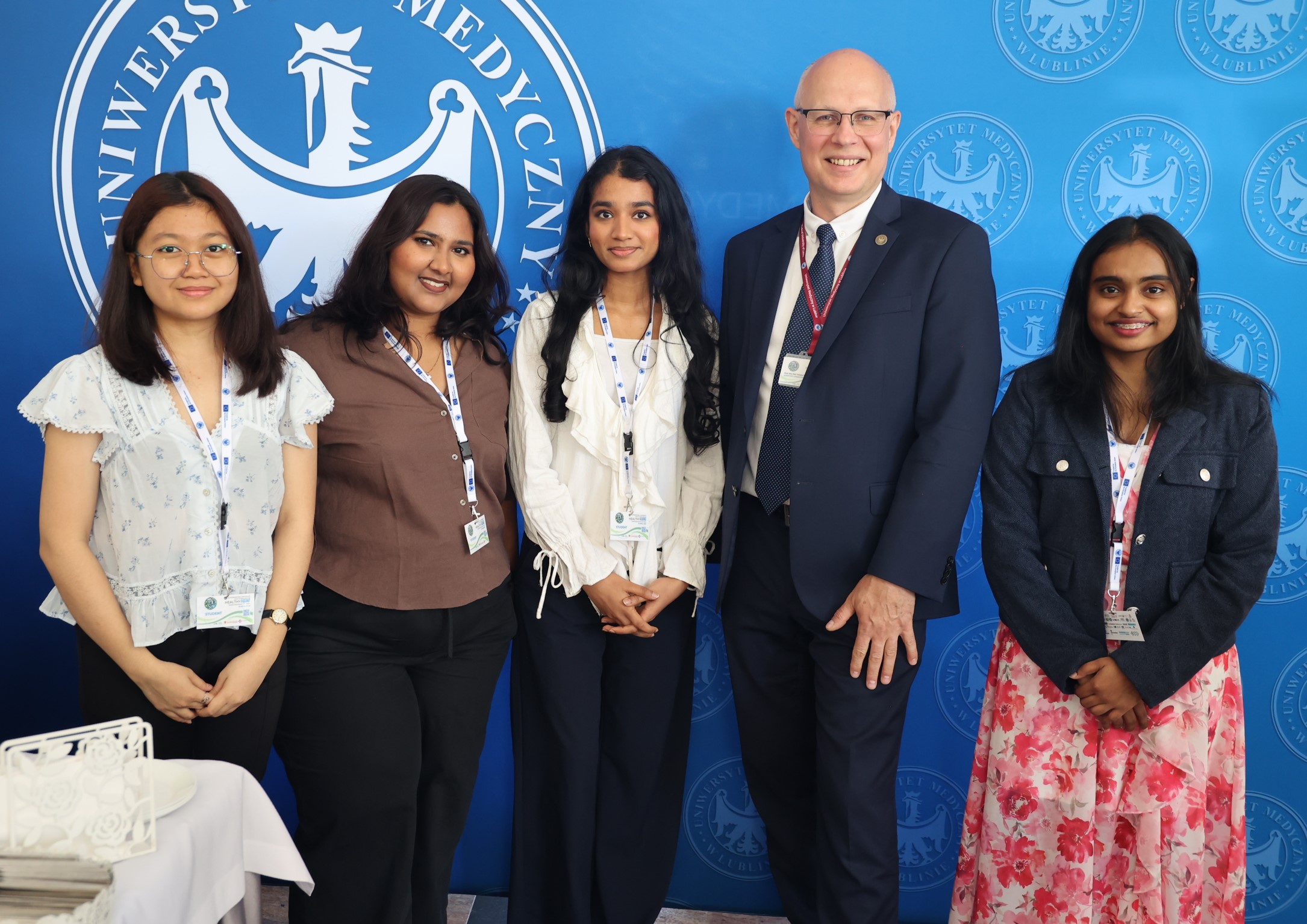 zagraniczne studentki UMLUB z prof. Tomaszem Blicharskim pozują na uczelnianej ściance